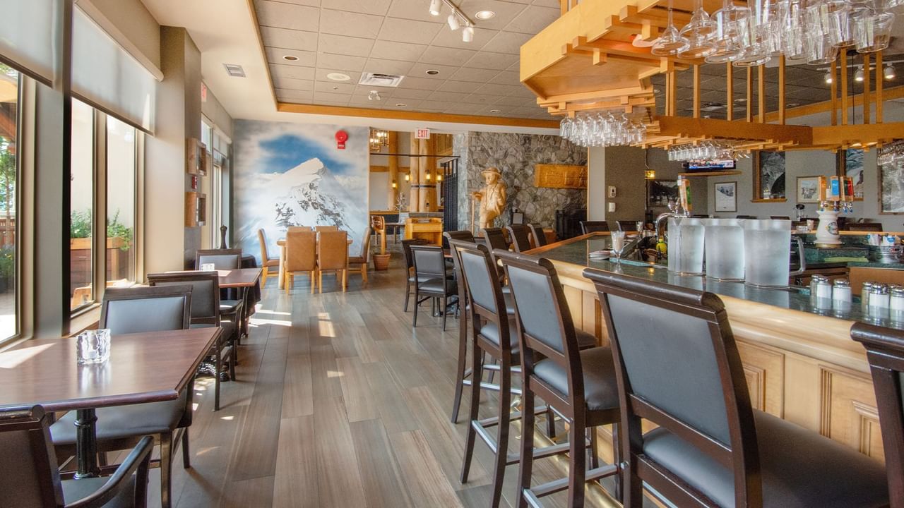 Hotel restaurant with dining table, chair, and bar