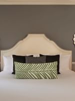 Bed between the side tables under hanging mirrors in the Marion Suite at Warwick New York