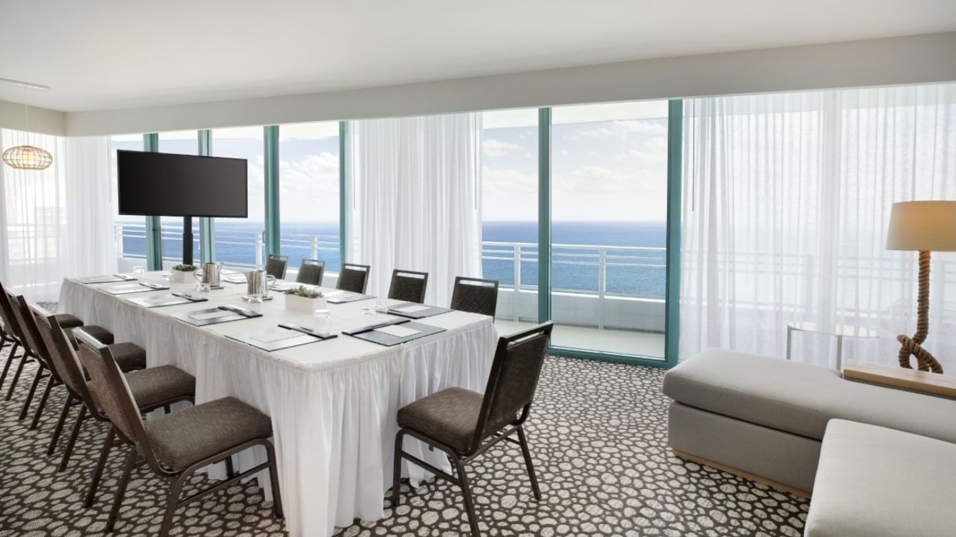 Boardroom set-up with cozy sofa & TV in Corner Oceanfront Suite at The Diplomat Resort