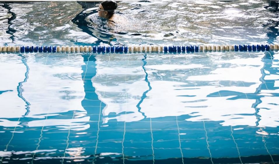 A woman swims in an indoor pool at Village Hotel Edinburgh