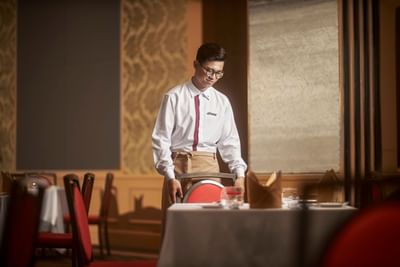 Waiter arranging a table in a restaurant at Hanoi Daewoo Hotel