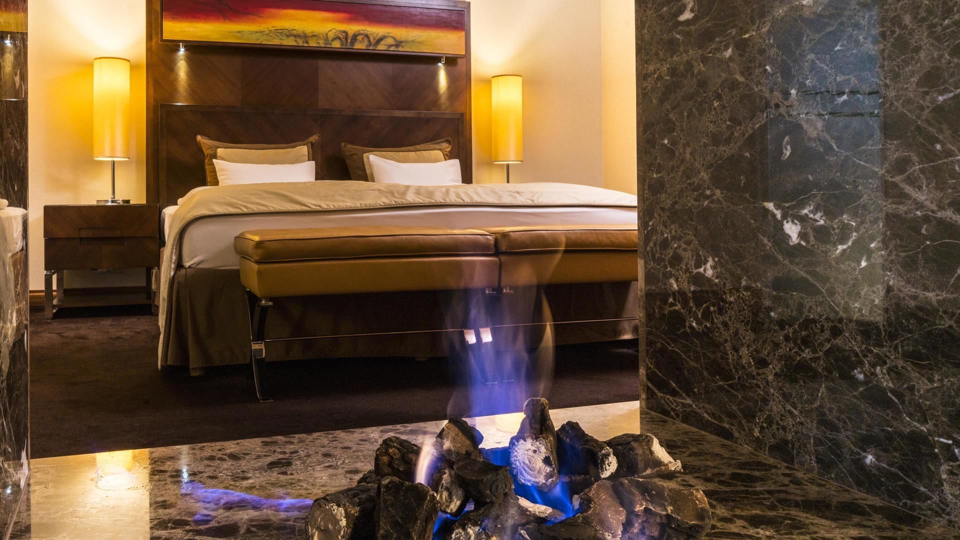 Fire pit & bed in Junior Suite Deluxe at Falkensteiner Hotels