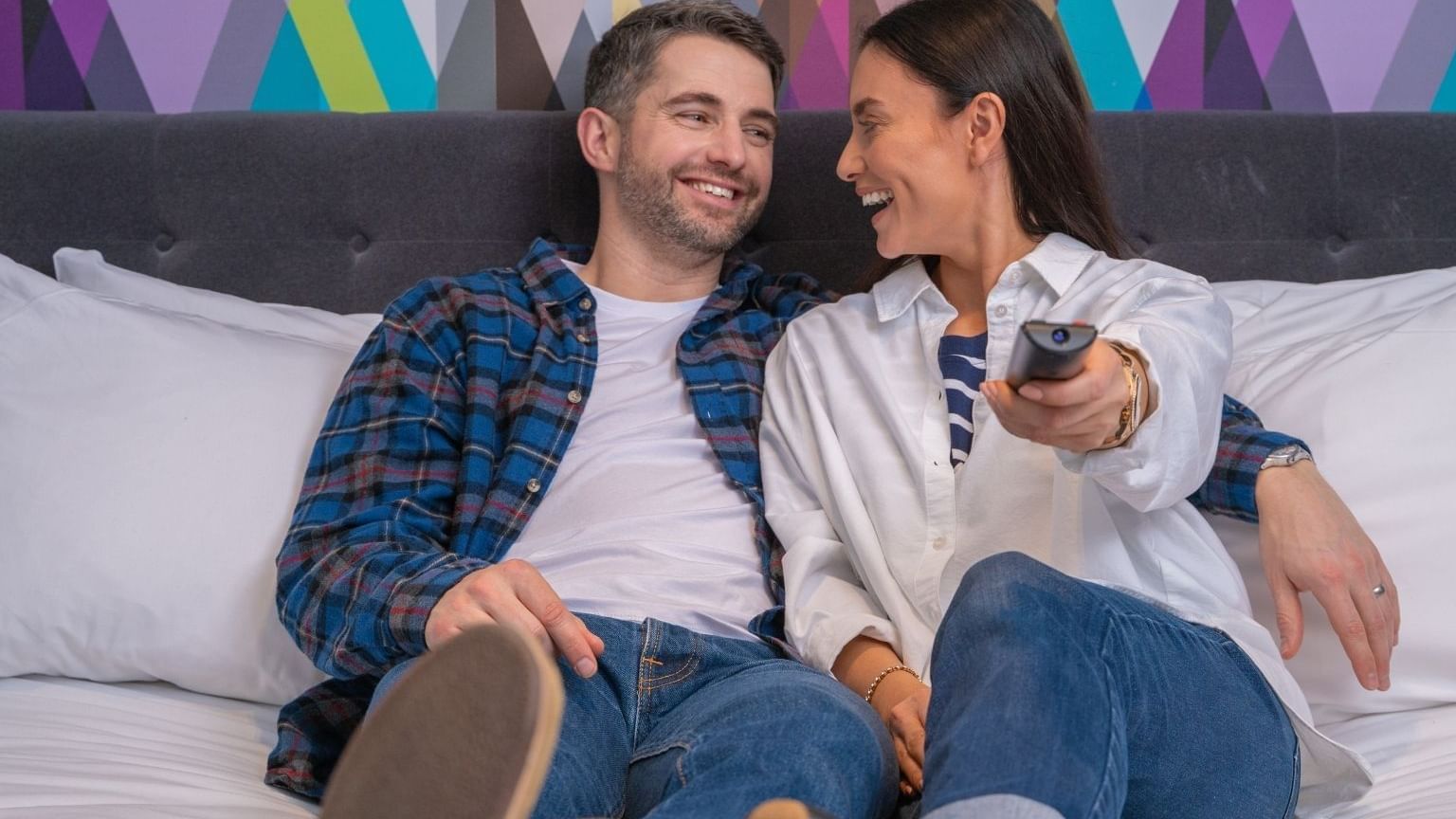 A couple watching tv in a guest room at Village Hotel Glasgow