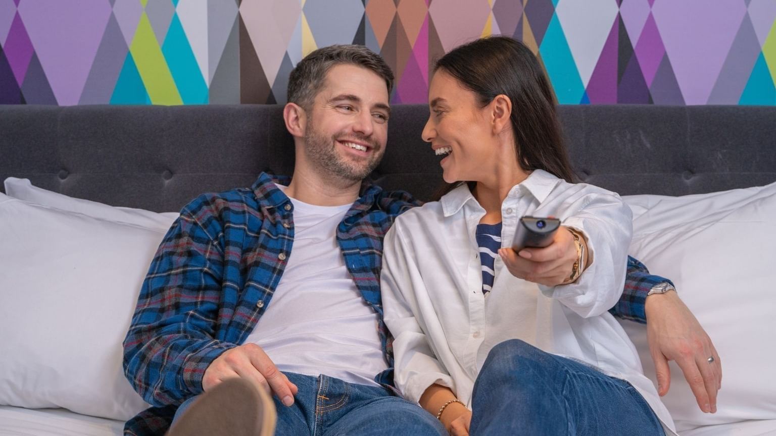 A couple watching TV in a room at Village Hotel Leeds South