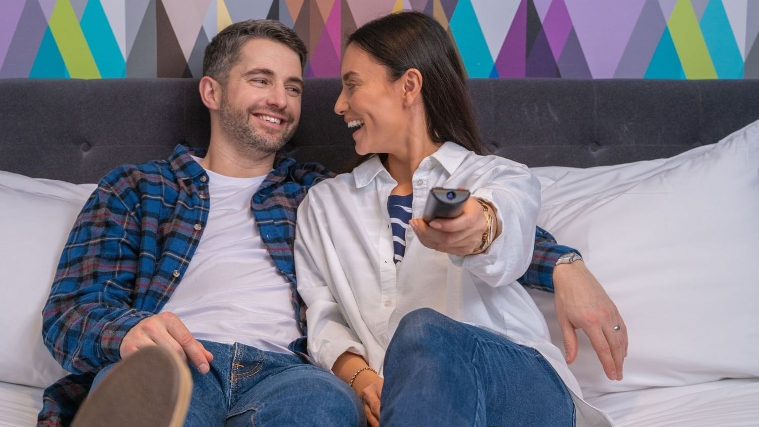 A couple watching tv in a guest room at Village Hotel Edinburgh