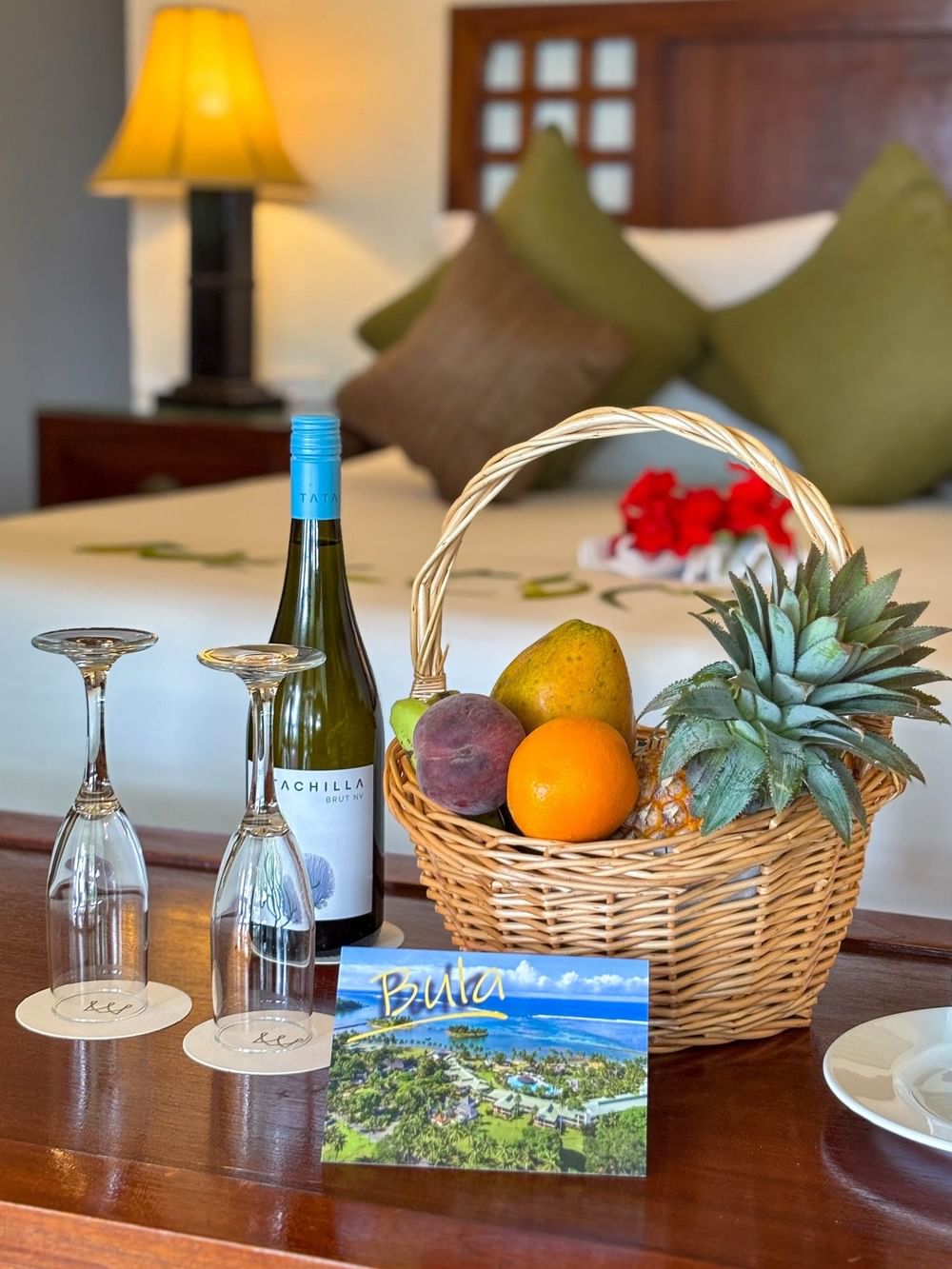 Bottle of wine and basket of fruits on table in Studio Villa at The Naviti Resort in Korolevu.