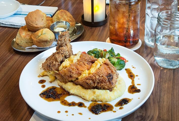 A plate of food with fried chicken, mashed potatoes, and vegetables.