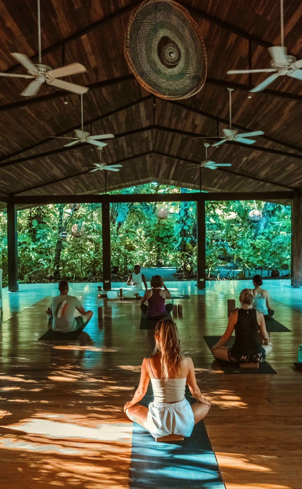 Guests practicing yoga in beautiful outdoor Lahari Wellness Center at Cala Luna Boutique Hotel