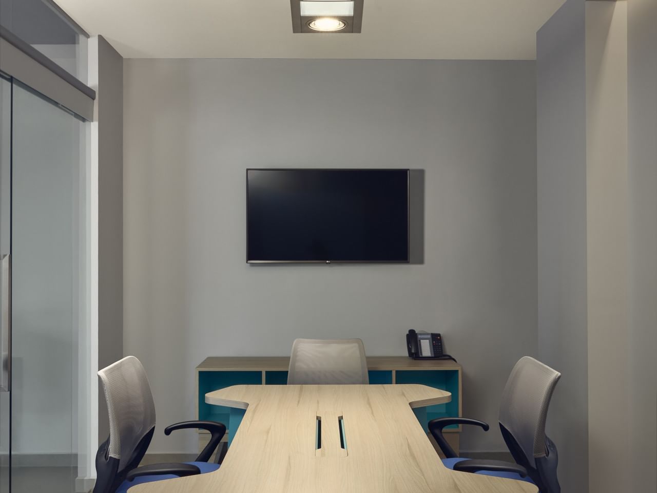 Mesa y televisor de pared en una sala de reuniones de One Hotels