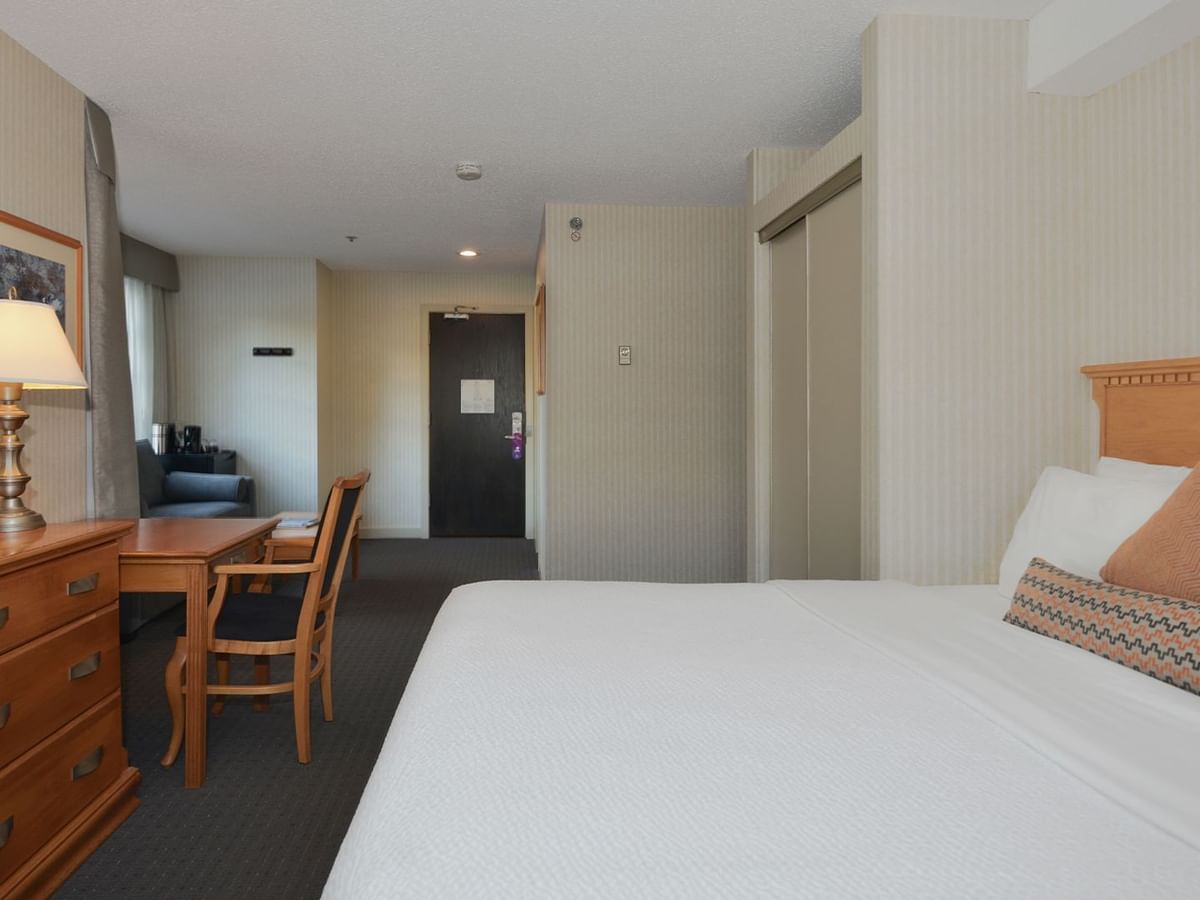 Hotel Junior Suite with king bed, HDTV, work desk and chair, and sofa.