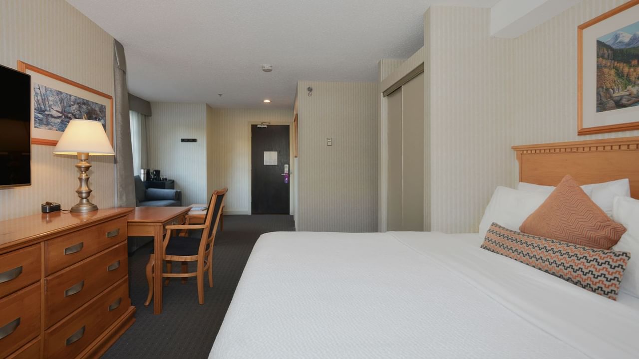 Hotel Junior Suite with king bed, HDTV, work desk and chair, and sofa.