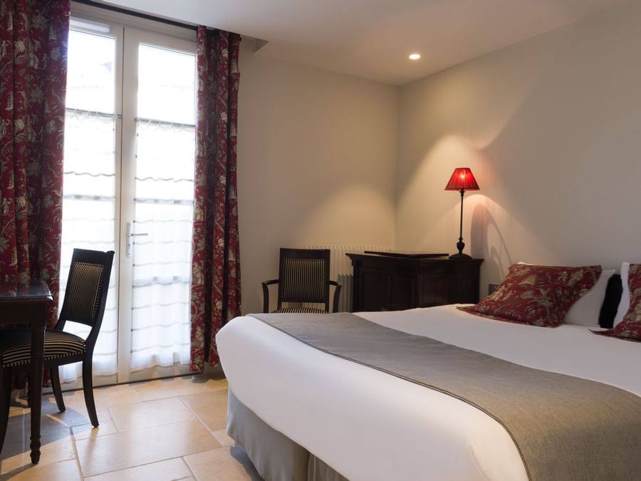 Triple bedroom with open windows at Hotel aux vieux remparts