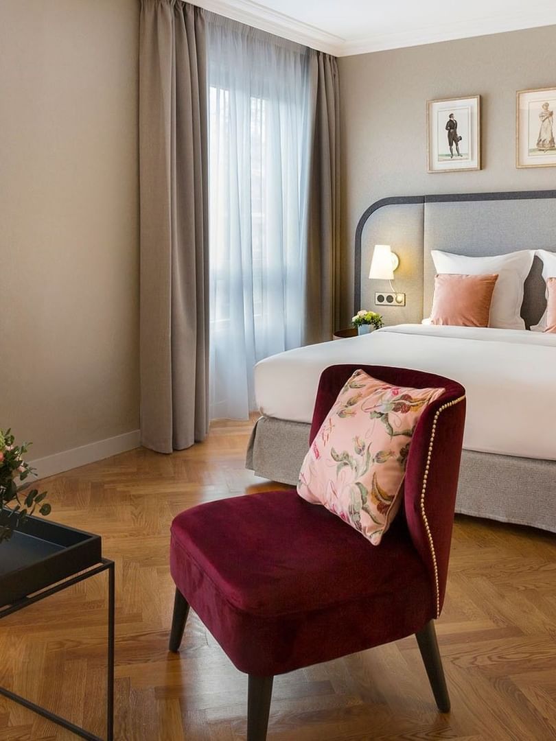 Seating area and nightstands by the bed with cushioned headboard in Deluxe Room at Warwick Reine Astrid - Lyon