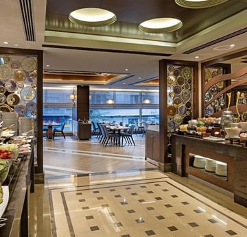 Alesta Restaurant with a buffet of fruits and vegetables, decorative walls, and a dining area with tables and chairs at Titanic City Taksim.