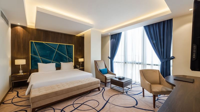 Comfy bed with sitting area in Junior Suite at Warwick Riyadh