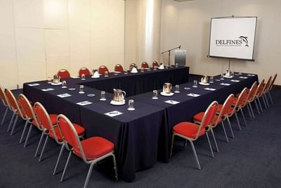 U-shaped table set-up in Triton with a projector screen and carpeted floors at Hotel Los Delfines & Casino