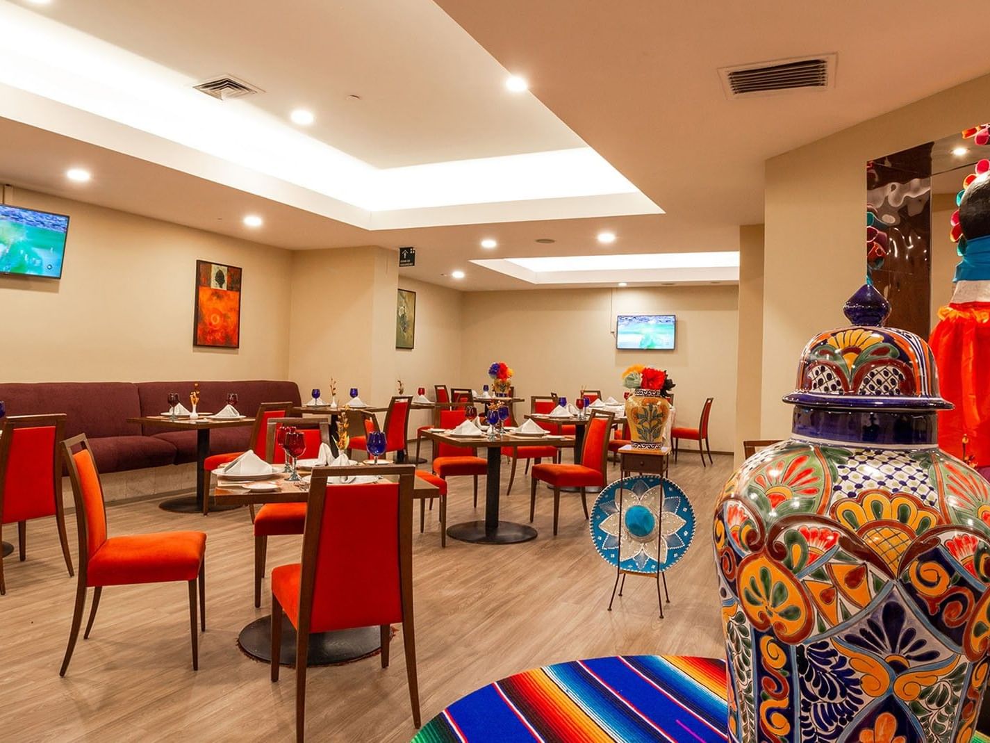 Comedor con mesas y sillas en Cualli, restaurante de Camino Real Aeropuerto México en Ciudad de México.