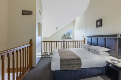 King bed on the upstairs in a room at Nesuto Hotels