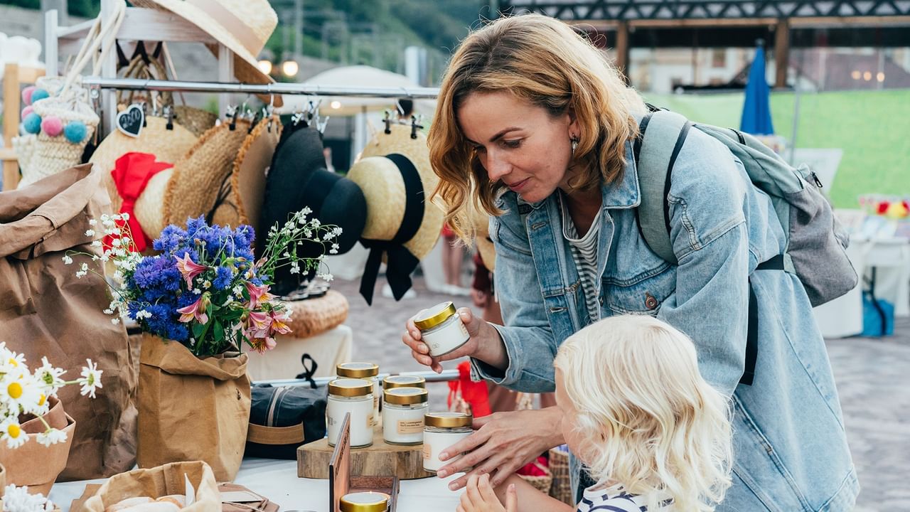 Mom and daughter browse candles at a craft market