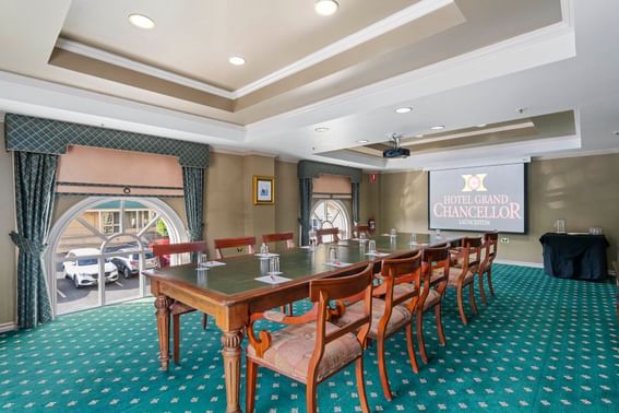 Meeting room set-up with projector & green pattern matte floor at at Hotel Grand Chancellor Launceston