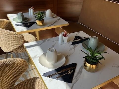 Tables élégantes avec vaisselle et plantes décoratives au Yachtman.