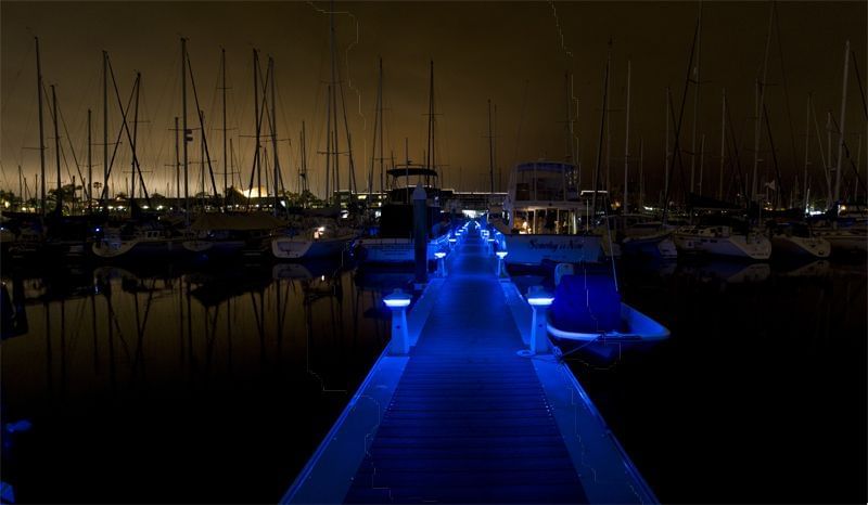 Blue lights outline a walkway in a marina at Bay Club Hotel