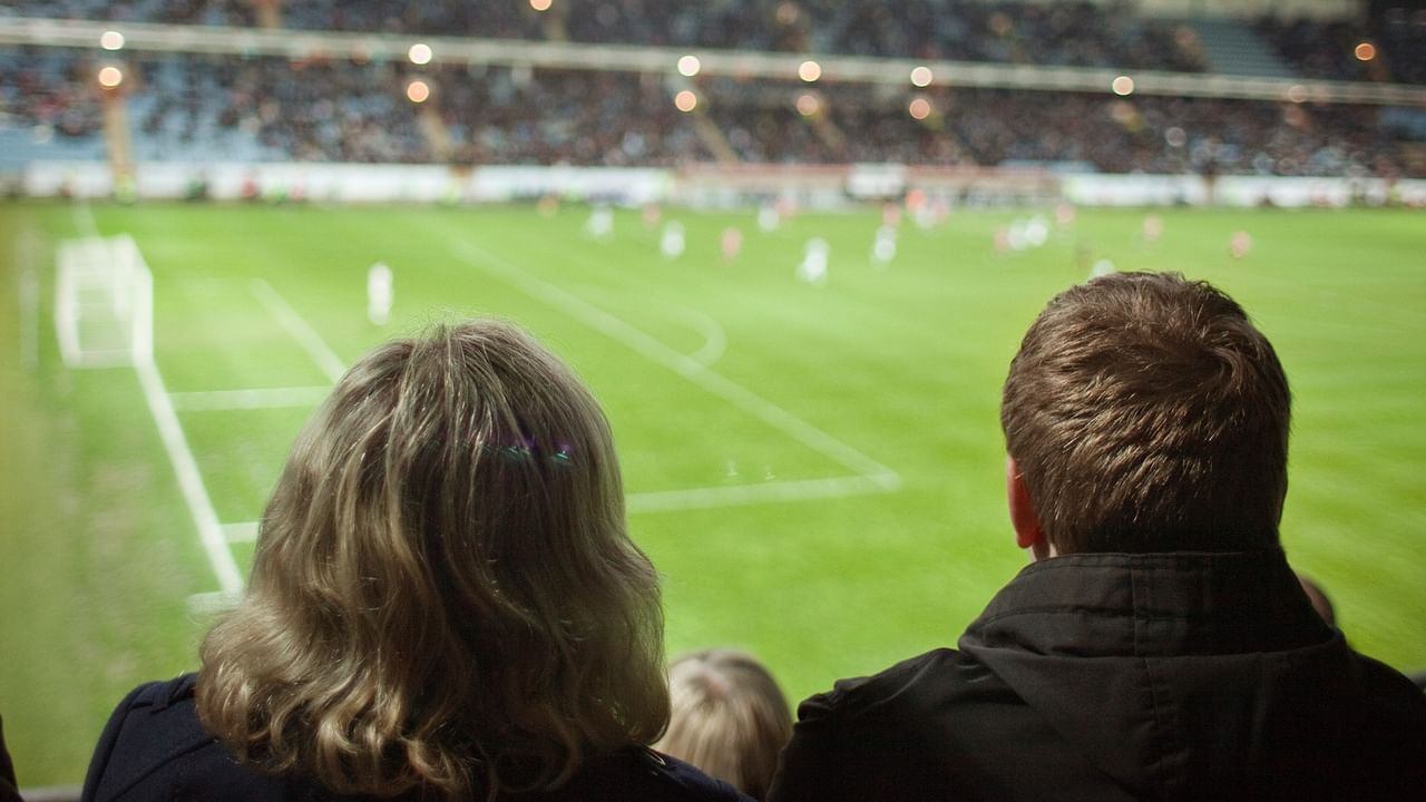 People watching a soccer match in an outdoor stadium