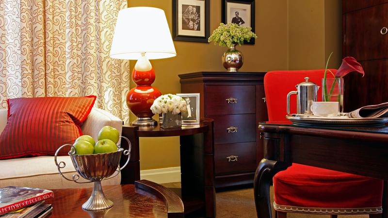 Living room with wooden table, chairs, and a lamp in Hollywood Suite at Warwick New York