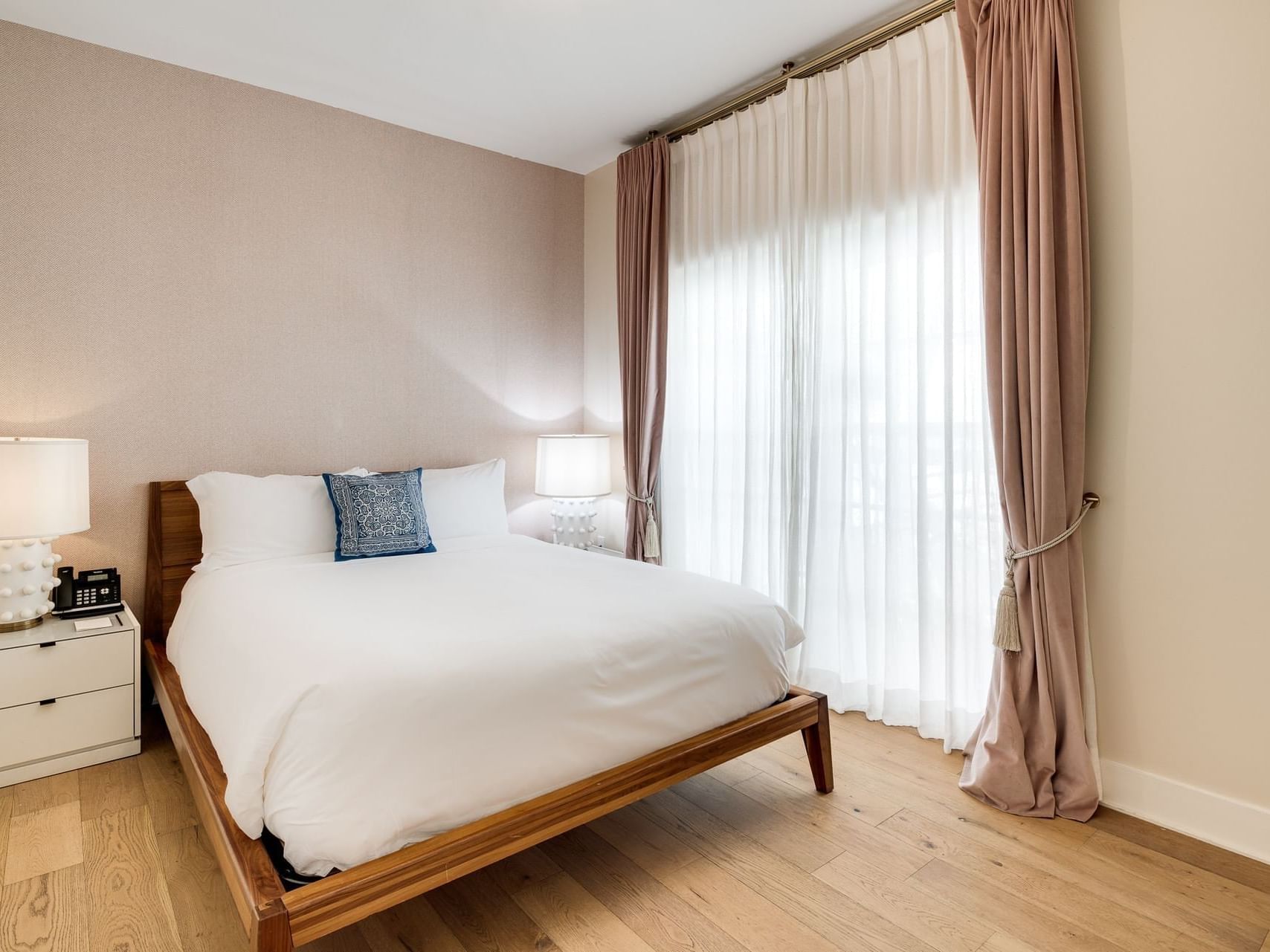 Grand One Bedroom Queen Suite with cozy bed and wooden floors at The Savoy Hotel & Beach Club