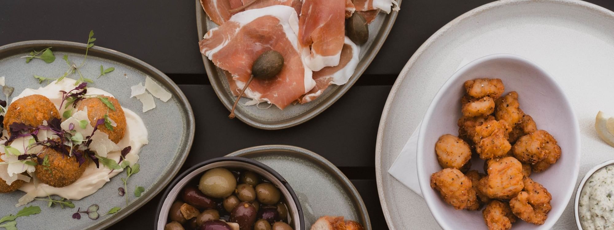 Delightful spread of charcuterie, olives, and fried bites served in The Cellar Kitchen Bar at Novotel Barossa Valley Resort