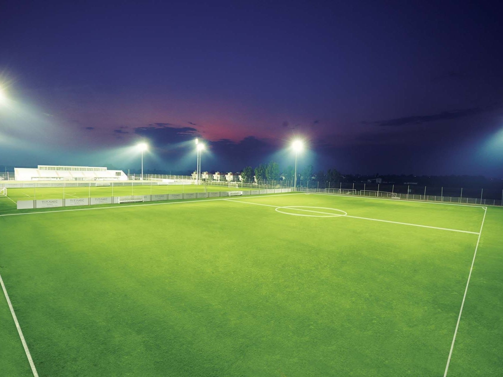 Empty greenery spacious soccer field at nighttime near Titanic Deluxe Golf Belek