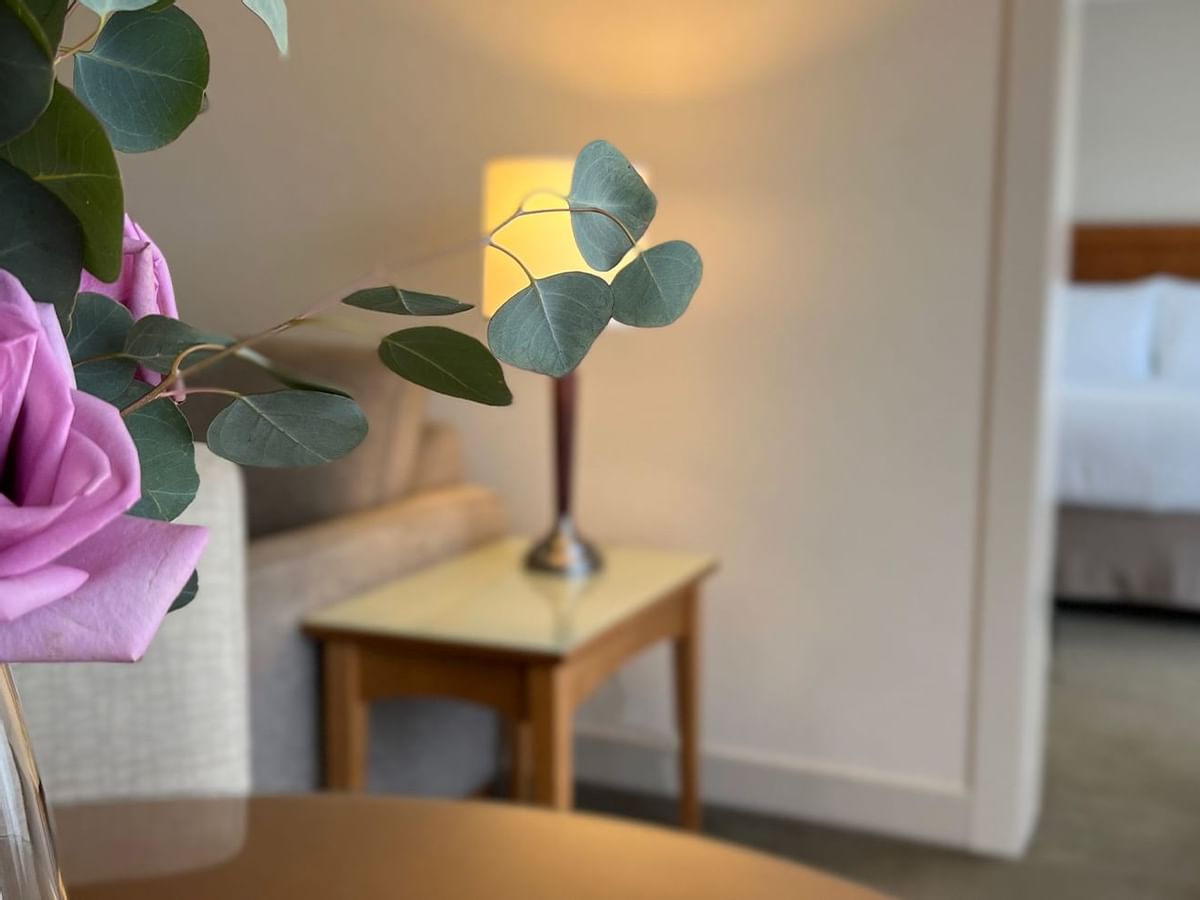 Up close shot of roses in vase with guest room in backround