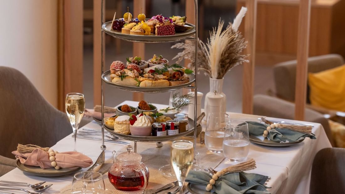 Beautifully arranged tea set with scones, pastries, and champagne served in High Tea at Novotel Sunshine Coast Resort
