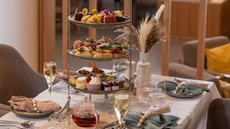 Beautifully arranged tea set with scones, pastries, and champagne served in High Tea at Novotel Sunshine Coast Resort