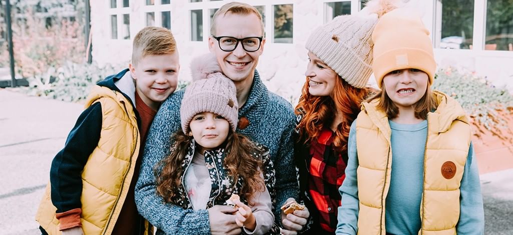 A family poses for a photo on Christmas Day in Canmore while eating S'mores.
