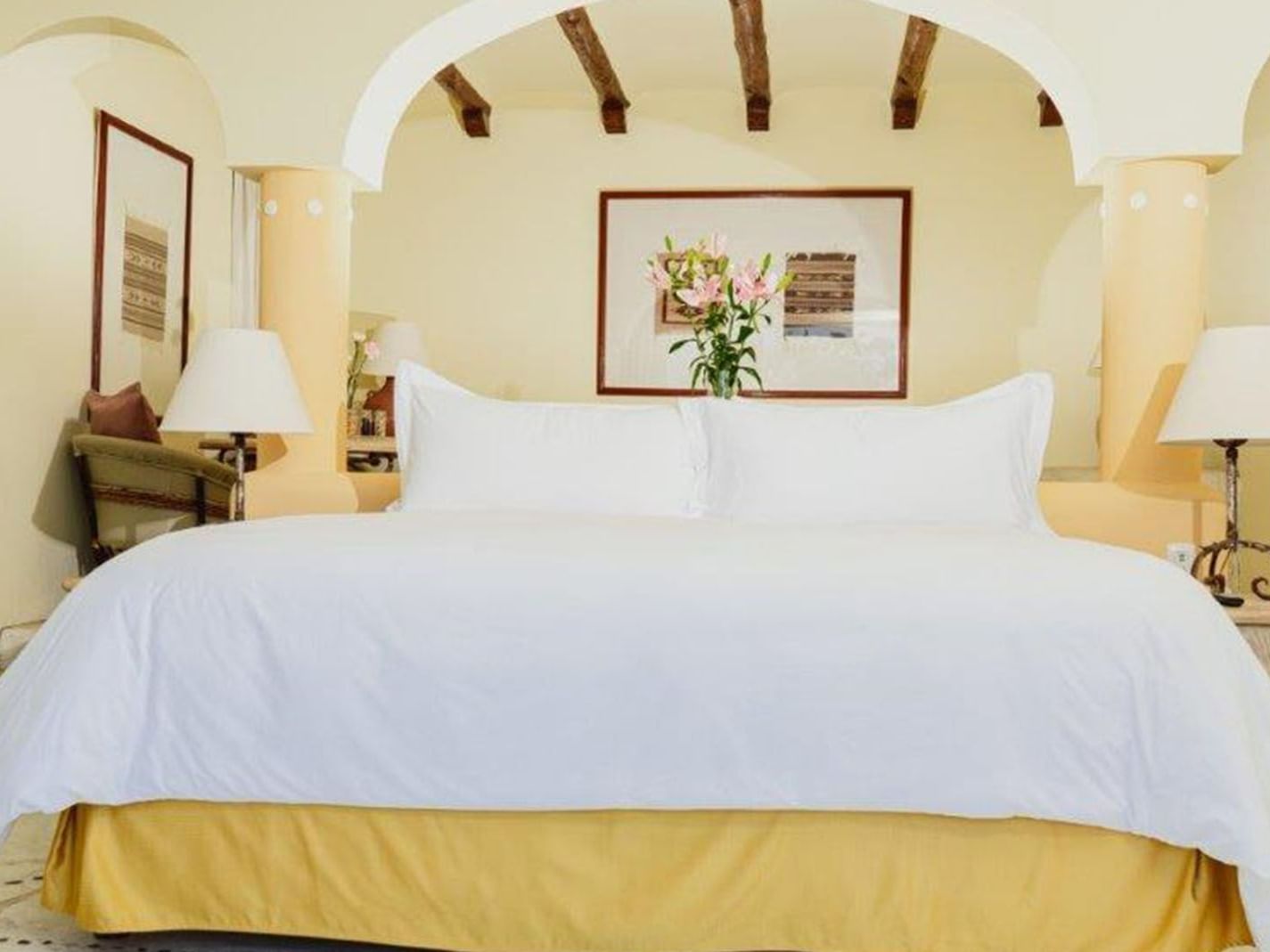 King Presidential Suite featuring a plush king bed with warm yellow lighting at Quinta Real Huatulco
