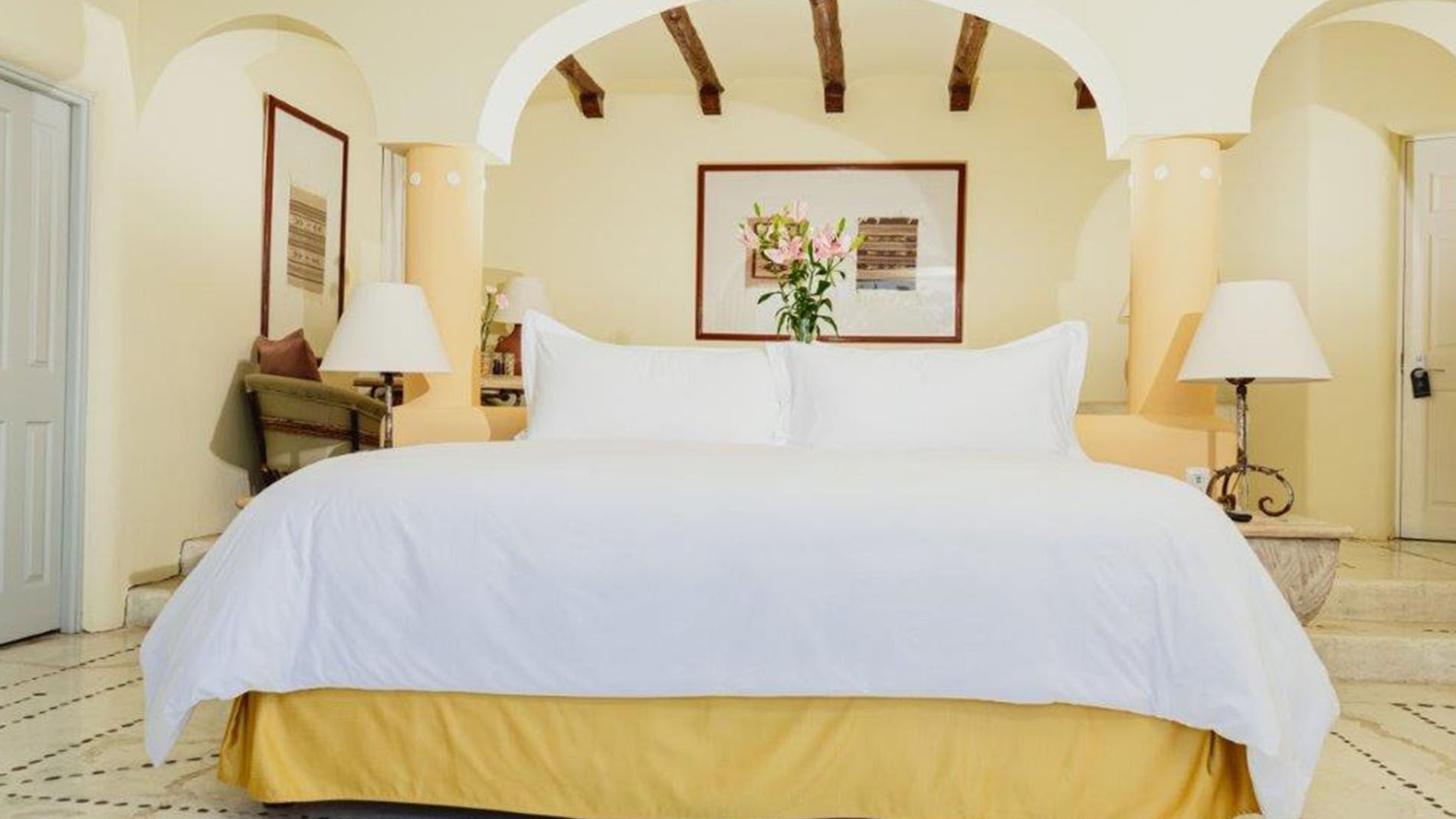 King Presidential Suite featuring a plush king bed with warm yellow lighting at Quinta Real Huatulco
