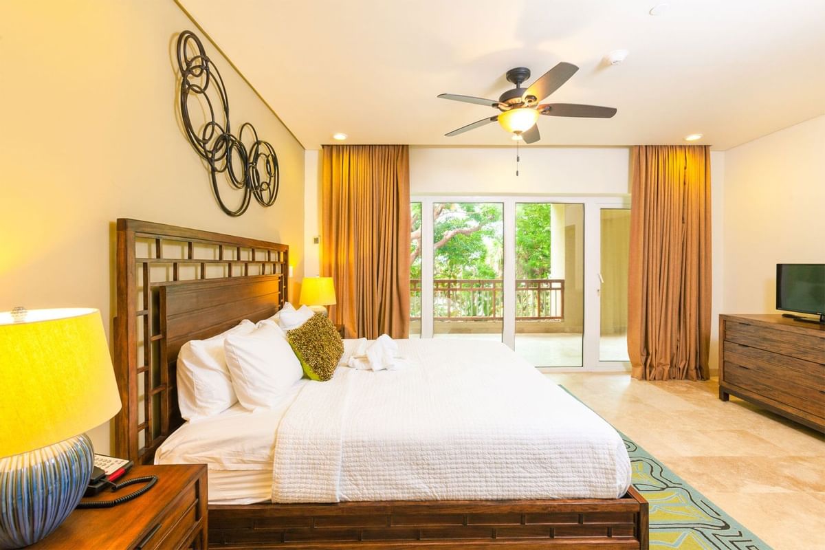 room with wooden bedframe and bed with dresser and balcony