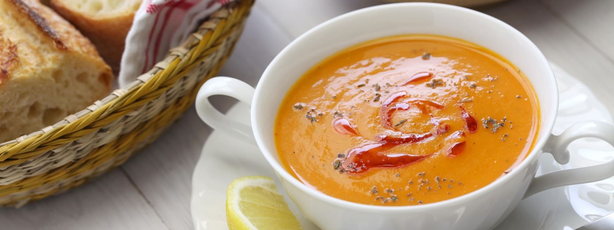 Plate of Mercimek corbasi served with lemon and bread in a restaurant at Warwick Ankara
