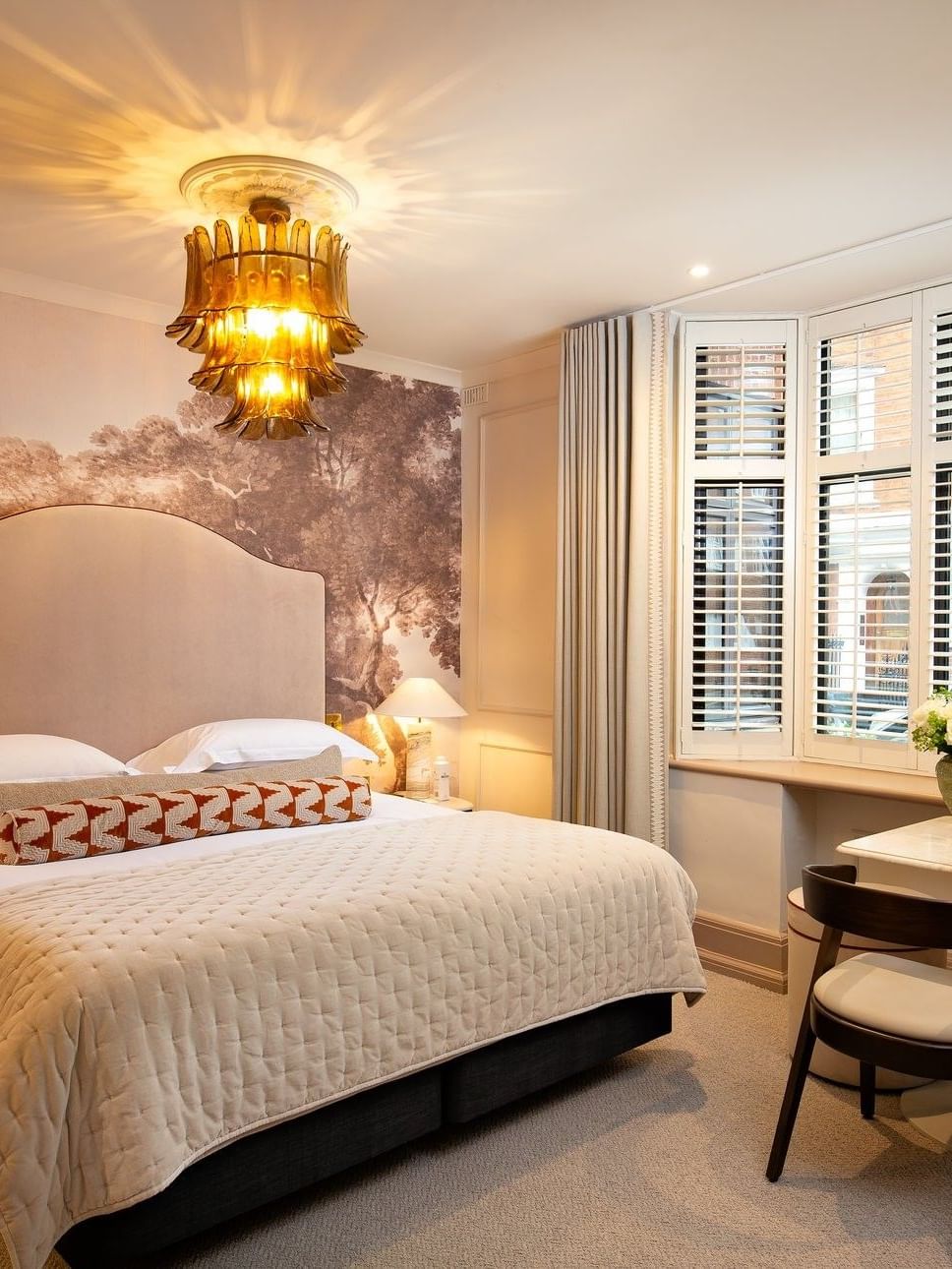 Bed with side tables and a working desk near window in Studio Apartment at The Capital Hotel, Apartments and Townhouse