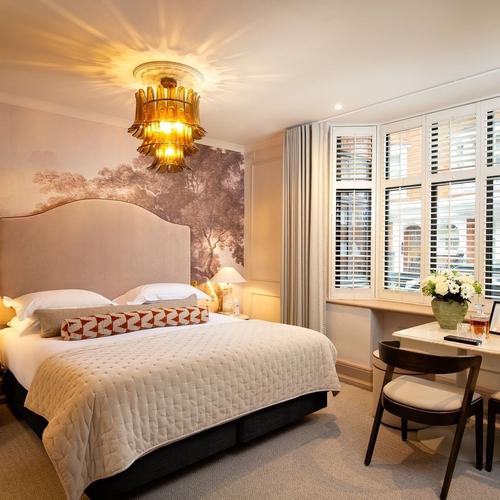 Bed with side tables and a working desk near window in Studio Apartment at The Capital Hotel, Apartments and Townhouse