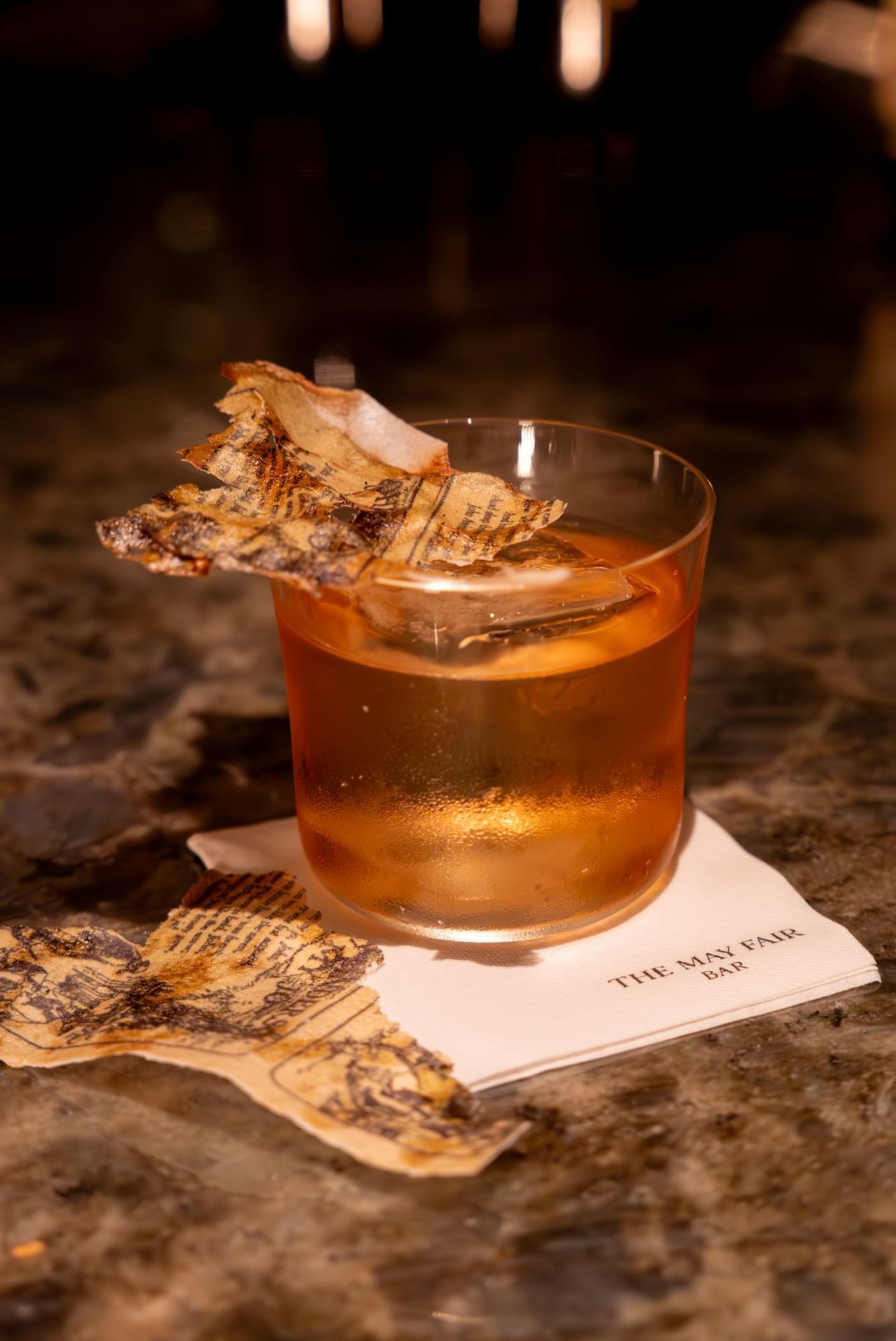 A cocktail glass of Lomond with edible poetry at The May Fair Bar