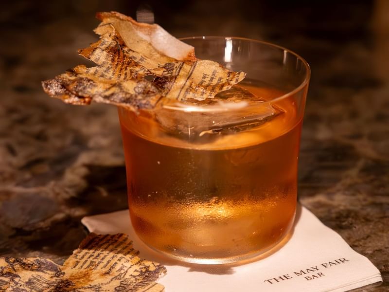 A cocktail glass of Lomond with edible poetry at The May Fair Bar