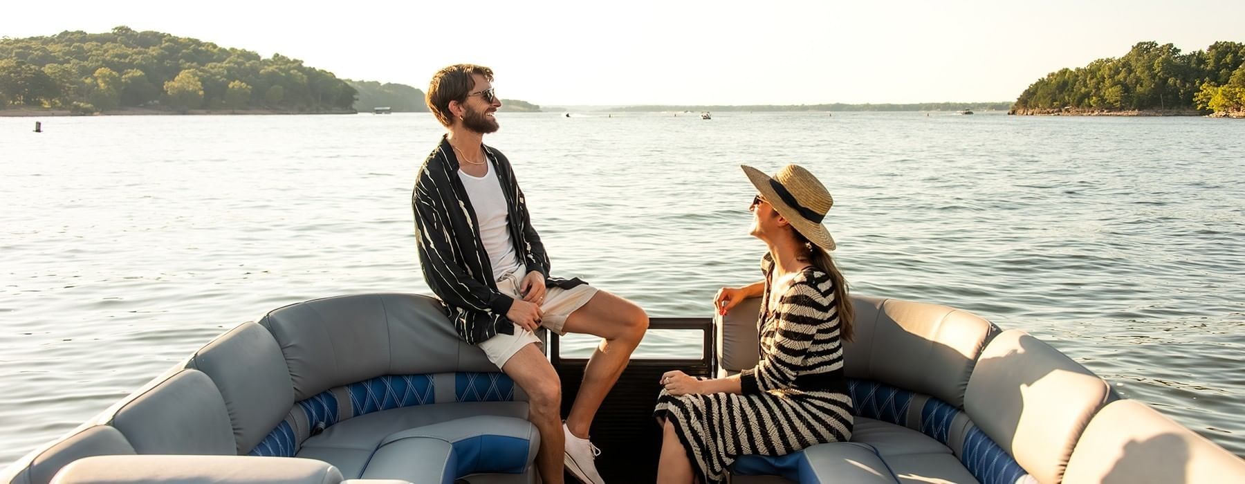 Happy couple enjoying a scenic boat ride near Shangri-La Resort and Golf Club on a sunny afternoon