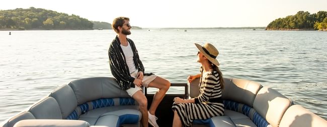 Happy couple enjoying a scenic boat ride near Shangri-La Resort and Golf Club on a sunny afternoon