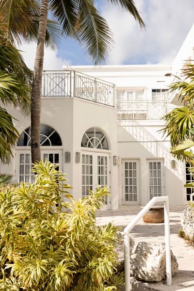 Exterior view of The Savoy Hotel & Beach Club surrounded by palm trees