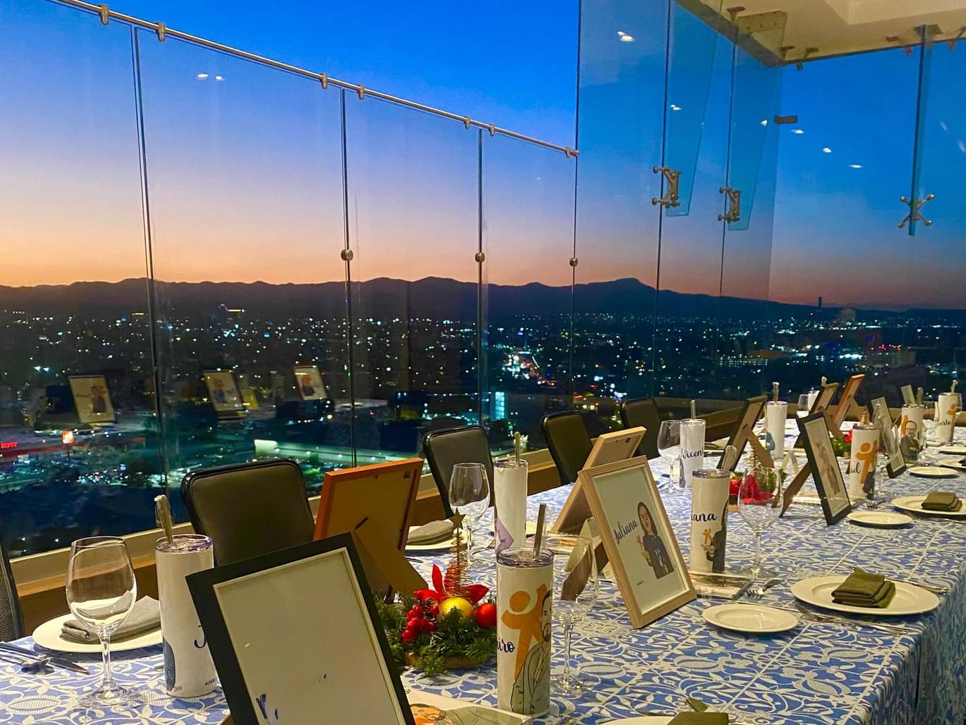 Elegant dining table set in Tangamanga Terrace with gifts, overlooking sunset cityscape at Fiesta Americana San Luis Potosí