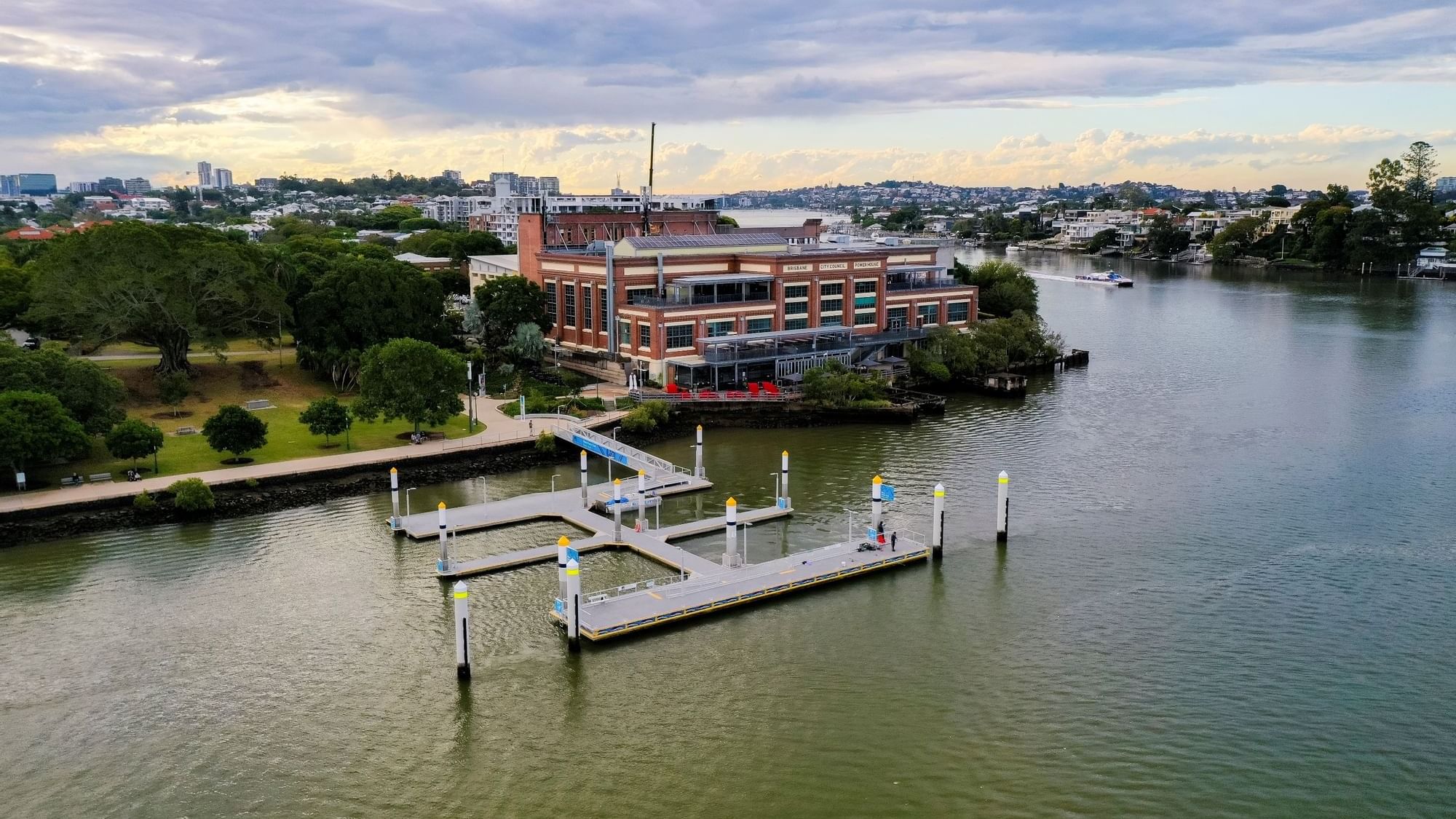 Aerial view of Brisbane Powerhouse by a river with cityscape near Sofitel Brisbane Central