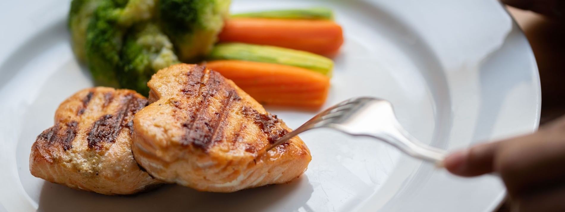 Grilled heart-shaped salmon fillets served alongside steamed broccoli & carrots in Seasons Restaurant at Warwick Hotel Jeddah