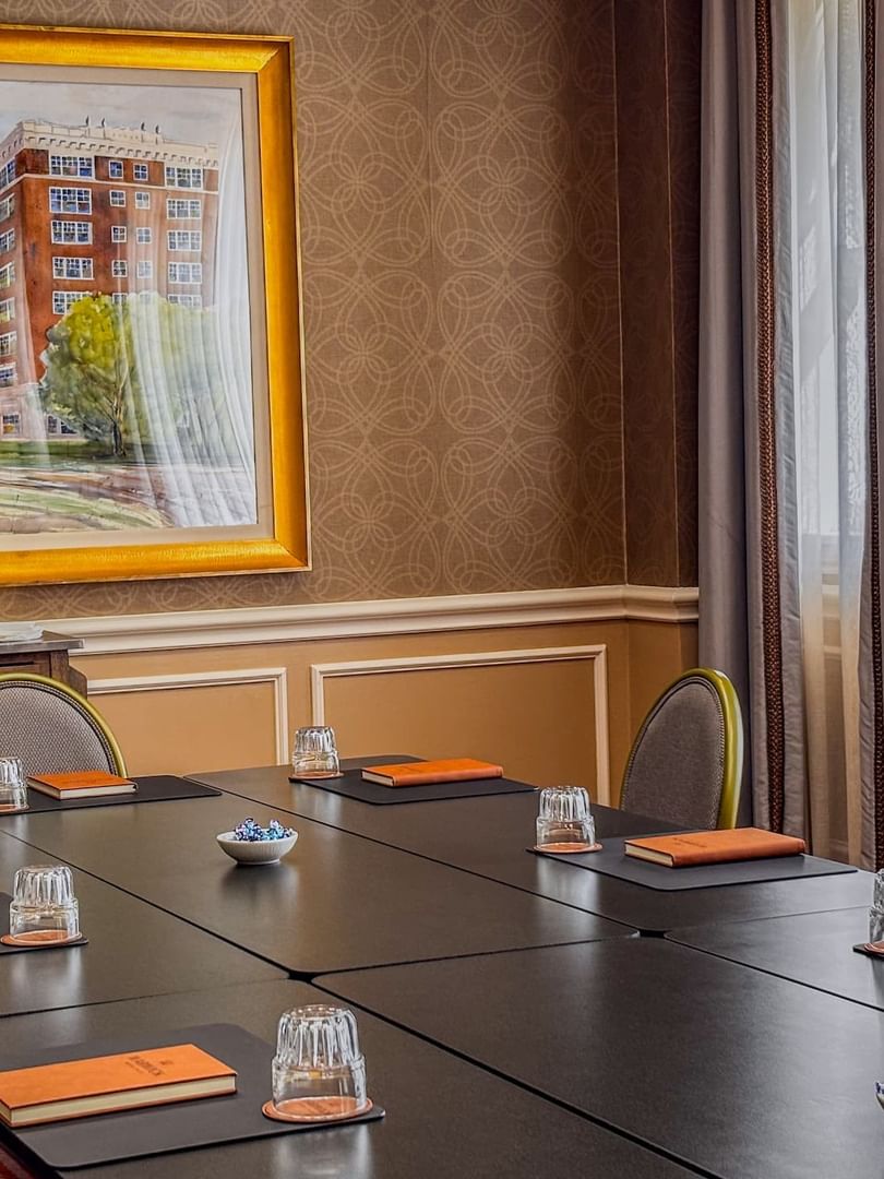 Black table by grey chairs under a large painting in Cedar Springs at Warwick Melrose Dallas
